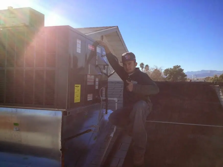 HVAC technician performing AC Tune-Up on a rooftop unit in Centerville